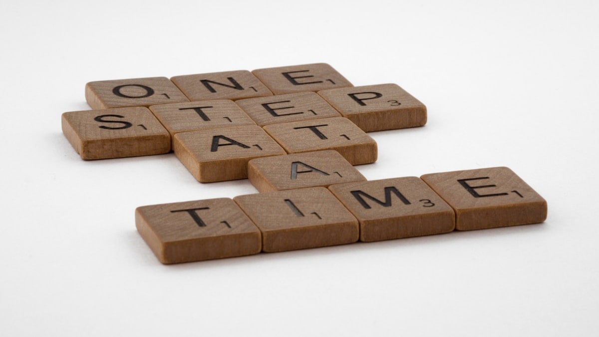 scrabble, scrabble pieces, lettering, letters, wood, scrabble tiles, white background, words, quote, letters, type, typography, design, layout, focus, bokeh, blur, photography, images, image, one step at a time, one day a time, one foot in front of the other, progress, don't give up, persevere, focus, intimidation, every journey, never give up, slow progress, slow and steady, steady as you go